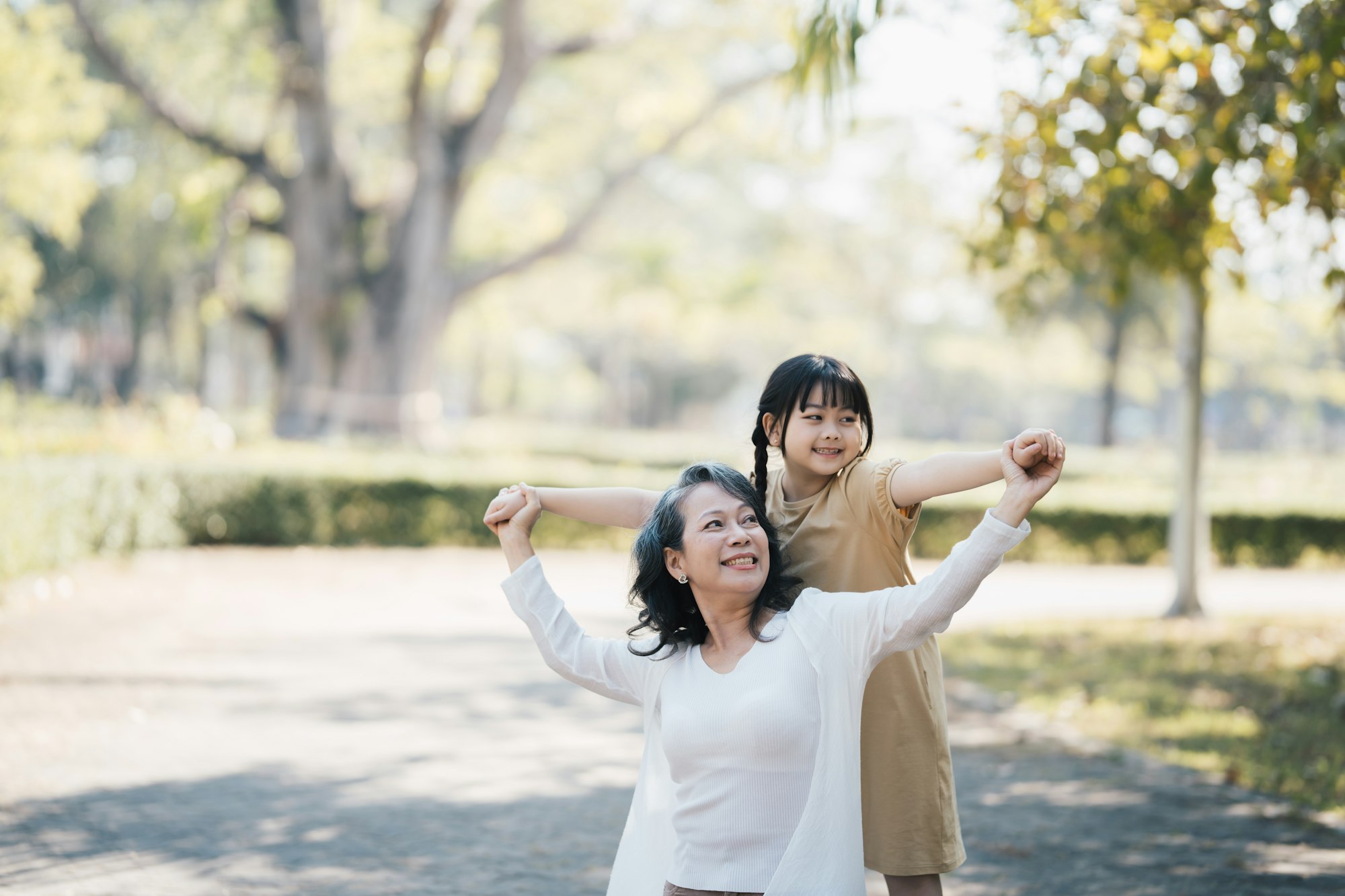 happy grandmother and granddaughter sharing time at summer park