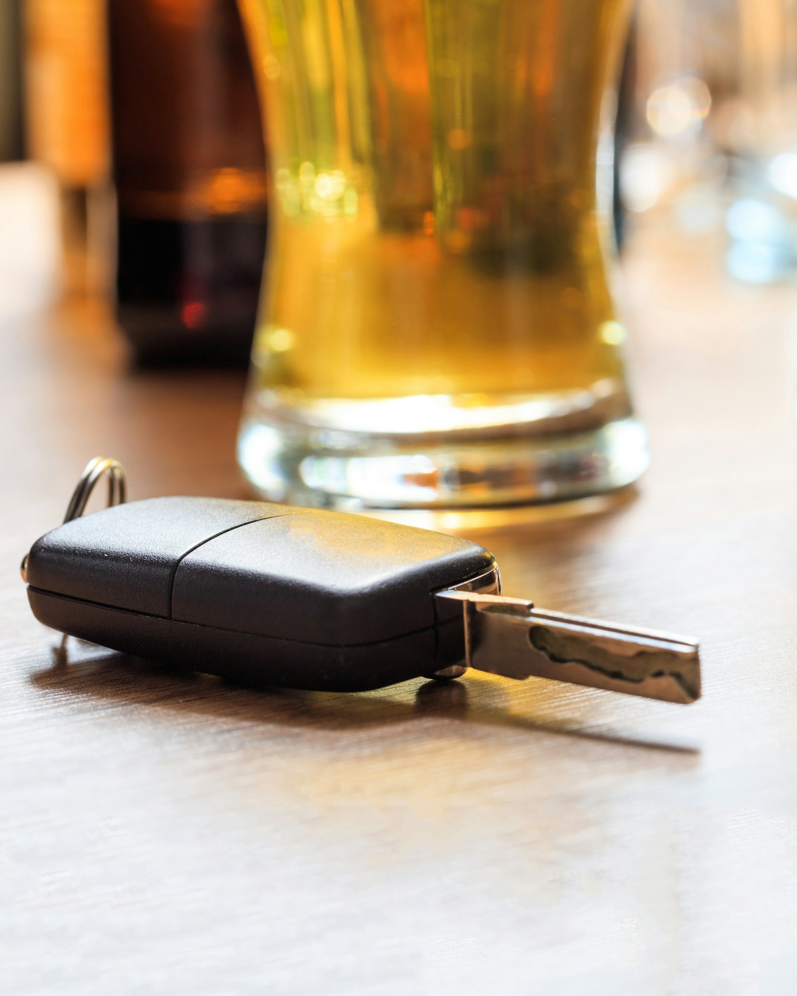 Drinking and driving. Car key on a pub counter, closeup view